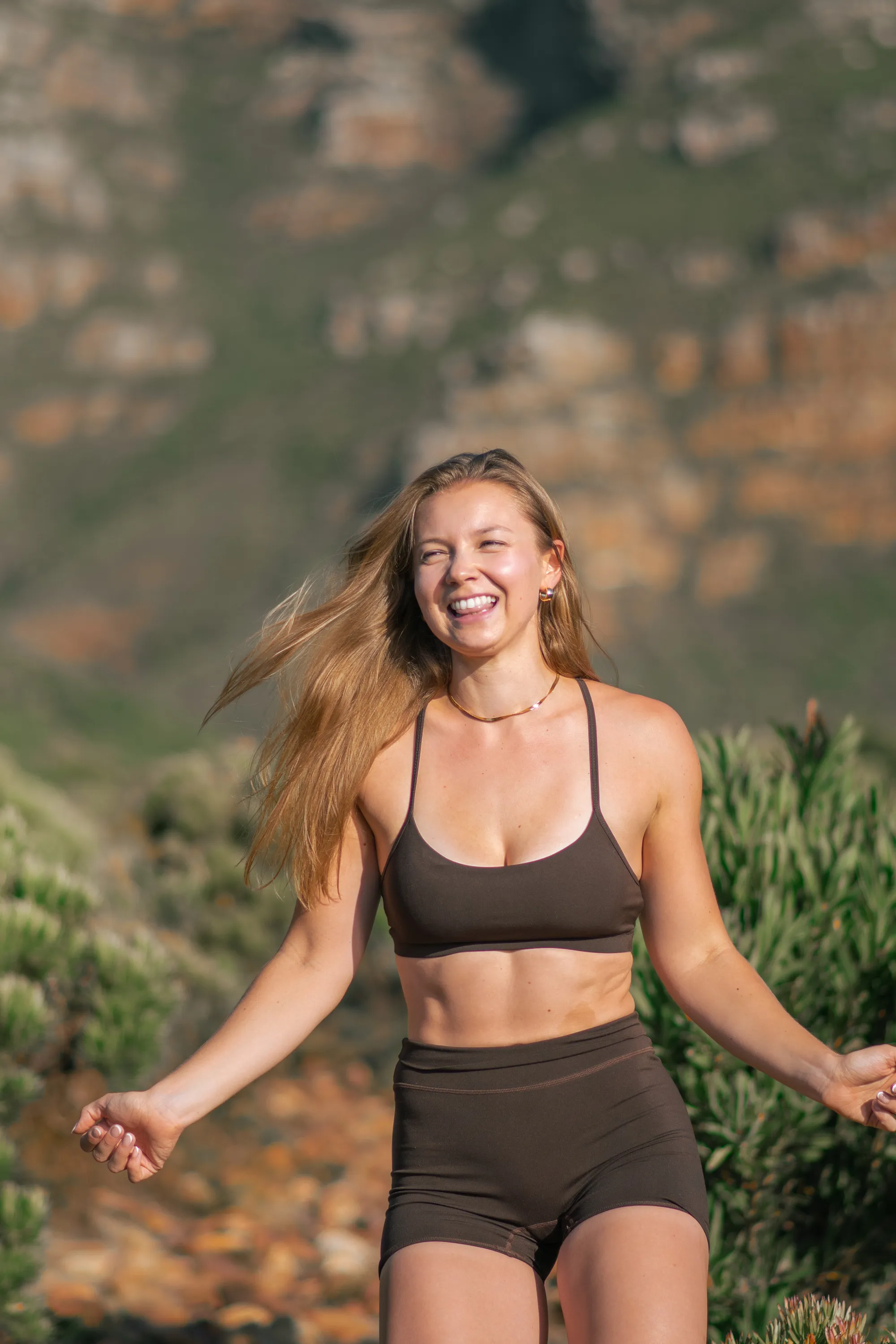 Madison laughing and running with mountain behind her